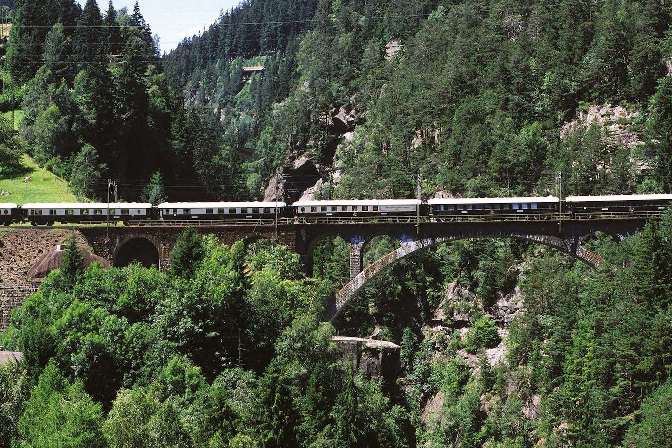 The Venice Simplon-Orient-Express train passing through the Swiss Alps en route to Venice.