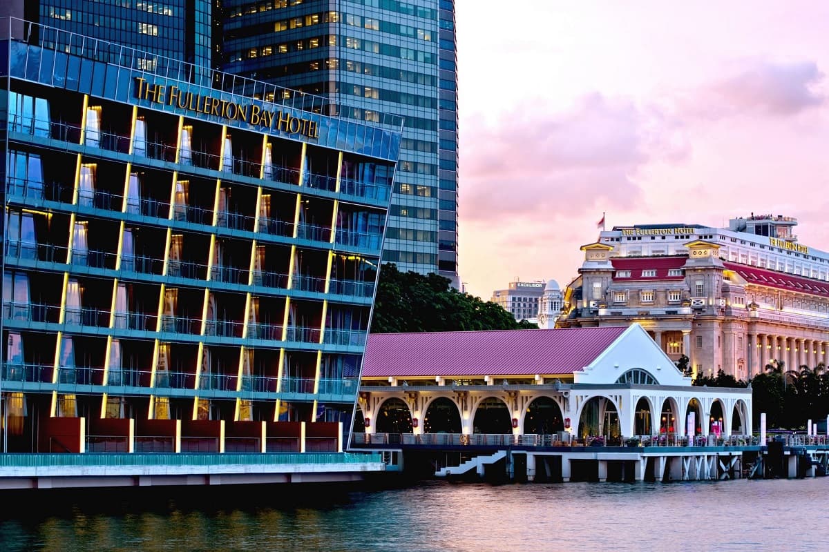 The facade of The Fullerton Bay Hotel and Clifford Pier at sunset.